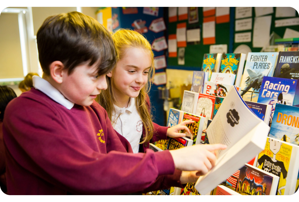 Two school children browsing Usborne books.