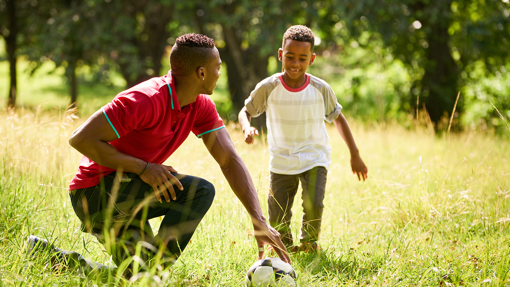 A boy and dad playing football