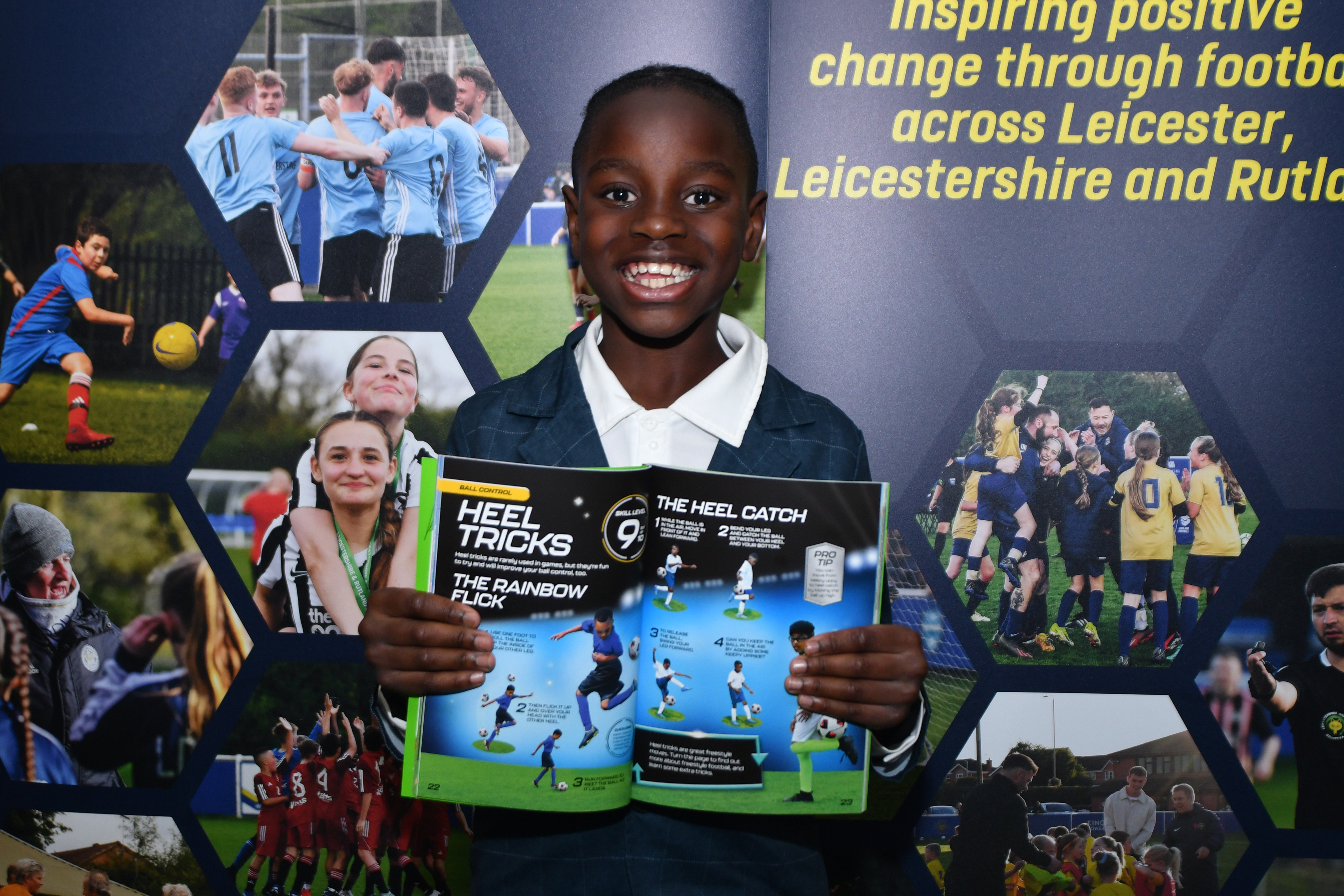Child smiling while holding a copy of a book open to a page about heel tricks.